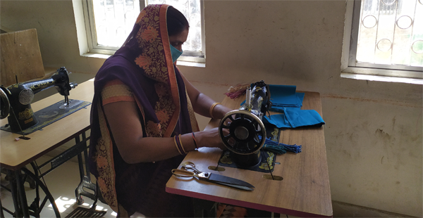 Artisan women sew handmade masks.