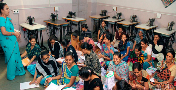 Women in classroom setting learning embroidery skills.